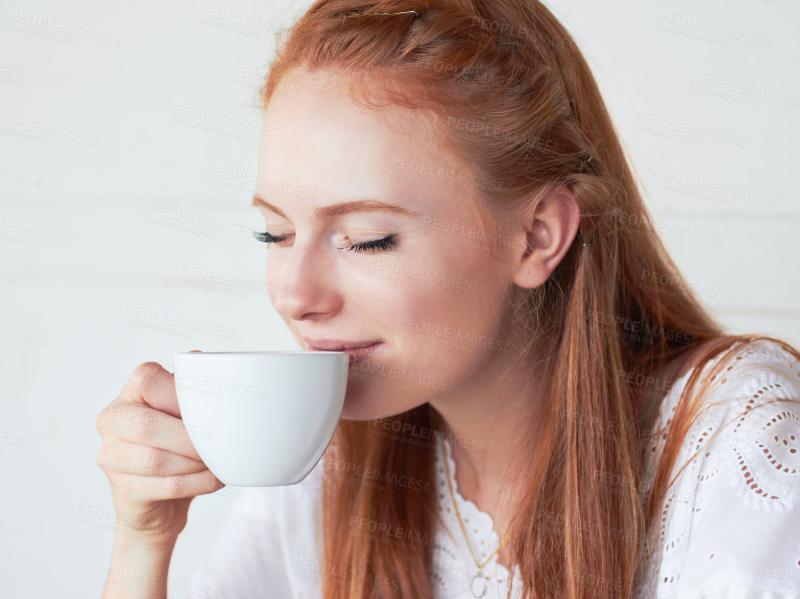 Buy stock photo Cropped shot of a young woman drinking coffee at a cafe