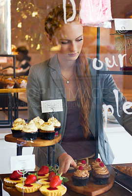 Buy stock photo Shot of an attractive young woman working in a bakery