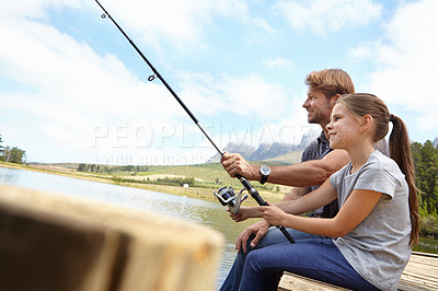 Buy stock photo Shot of a father showing his daughter how to fish