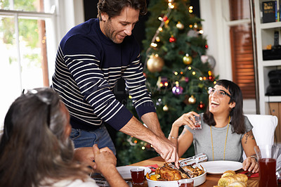 Buy stock photo Family, Christmas and dad serving food for festive lunch, bonding and eating together in home. Holiday, celebration and happy people at table with laugh, drinks and xmas dinner tradition with smile