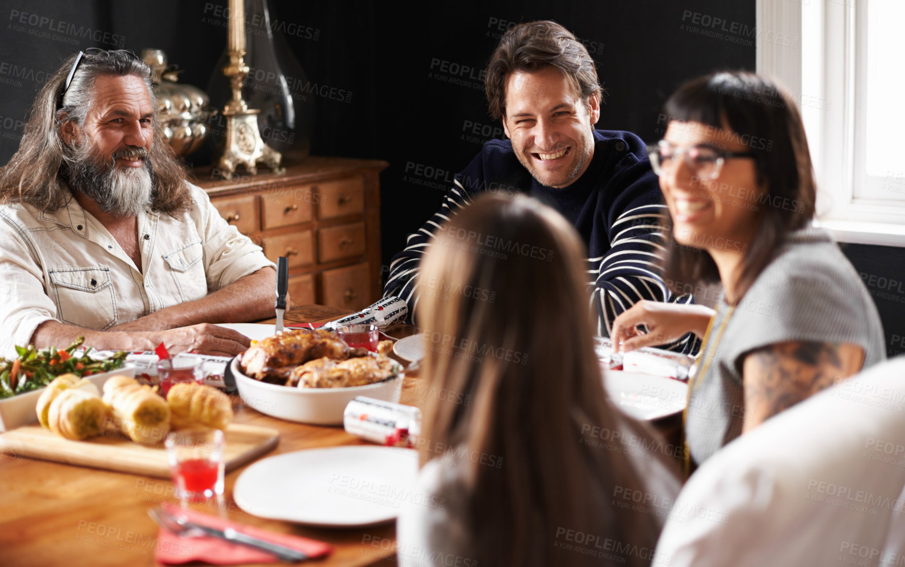 Buy stock photo Shot of a happily family smiling over christmas lunch