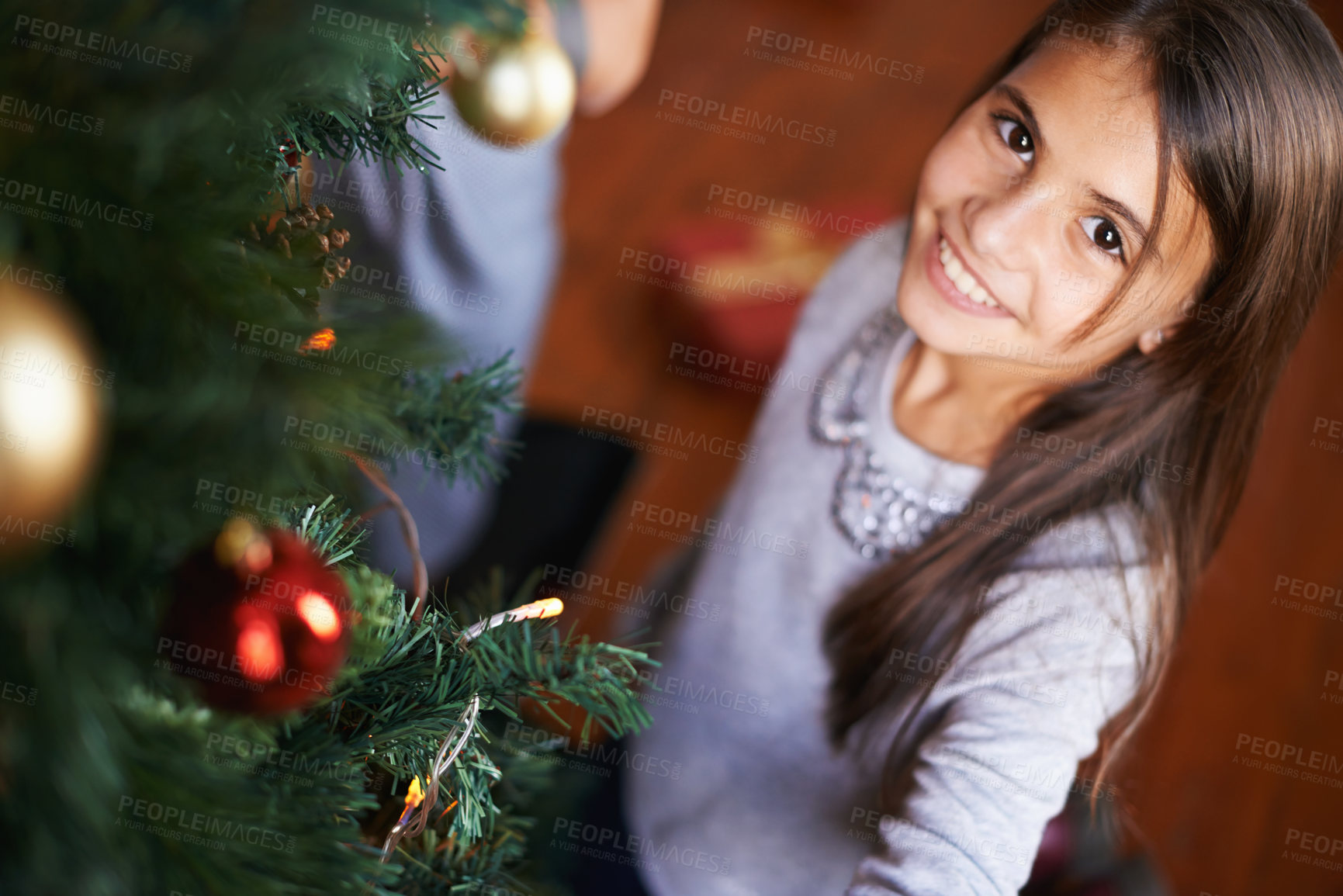 Buy stock photo Portrait, child and smile by Christmas tree in home, festive season and happy to prepare for xmas. Female person, girl and care for decoration on religious holiday, celebration and love for tradition