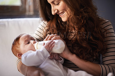 Buy stock photo Cropped shot of an adoring mother feeding her baby
