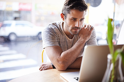 Buy stock photo Laptop, thinking and man freelancer working in a restaurant as remote work in a cafe or coffee shop and reading an email. Internet, website or serious male person or consumer blogging online in store