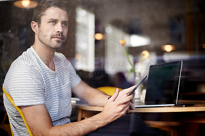 Buy stock photo Young man, vision and laptop with phone at cafe by window for social media or communication at indoor restaurant. Male person on mobile smartphone in wonder for online chatting or app at coffee shop