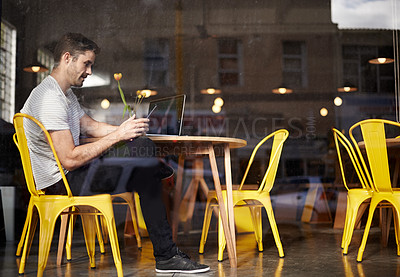 Buy stock photo Shot of a young man working at a coffee shop