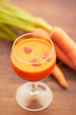 Buy stock photo Carrot juice, vegetable and healthy food or drink with color, art and nutritionist creativity. Vegan smoothie or orange liquid in glass for wellness, diet or nutrition on a wooden table with ice