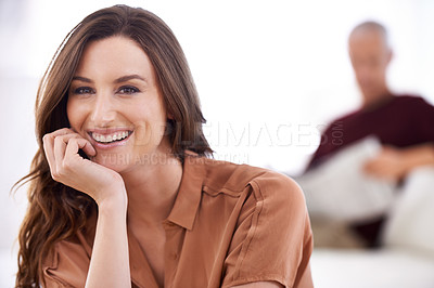Buy stock photo Shot of a smiling young woman and her mature husband reading the newspaper at home
