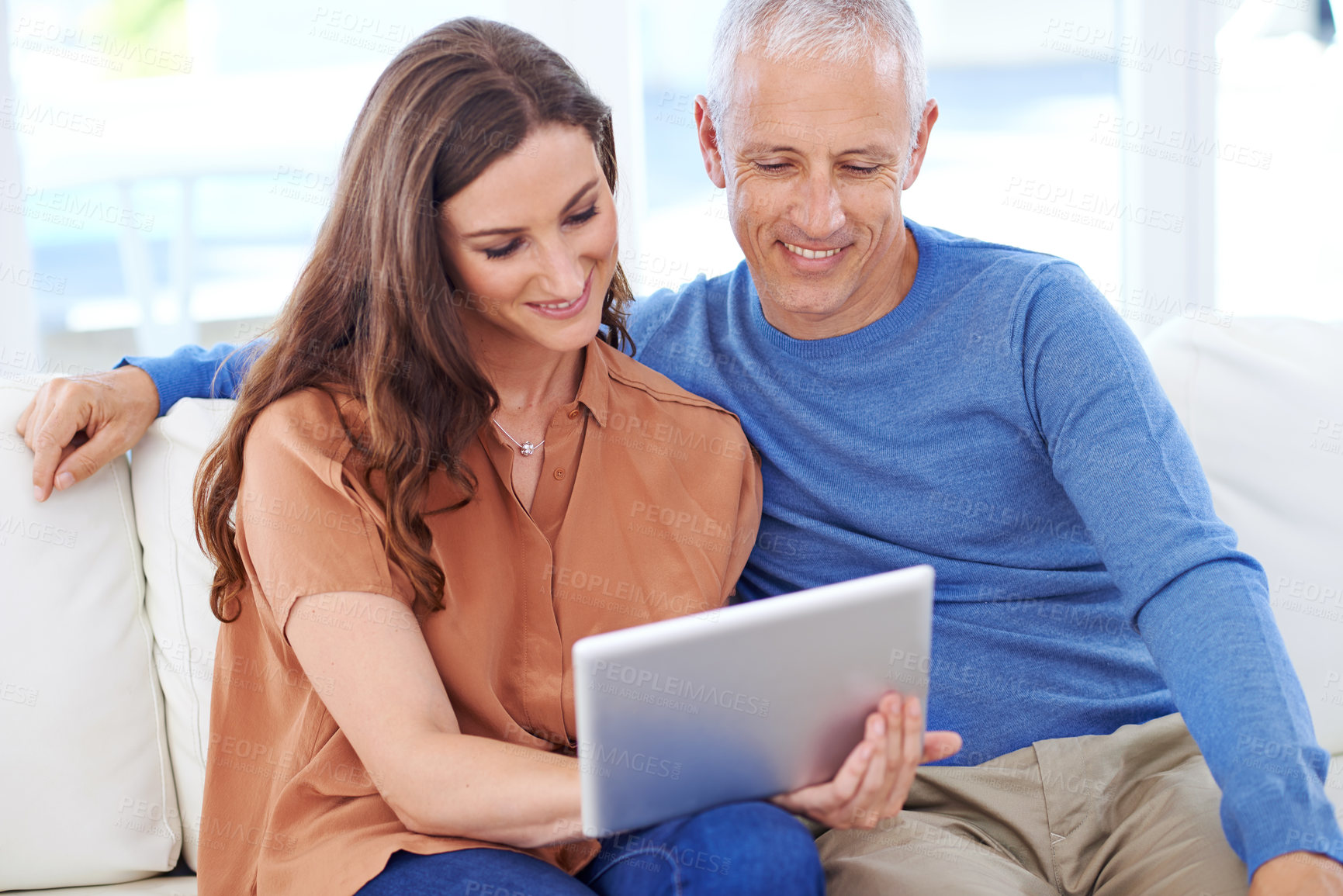 Buy stock photo Couple, tablet and smile on sofa to relax with reading, search and app to watch movie with bonding. People, woman and mature man on digital touchscreen for notification with web connection in house