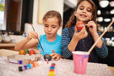 Buy stock photo Painting eggs, sisters and home with girls, smile and hobby with recreation and artistic with happiness. Easter, siblings or kids with child development or creative with tools or colour with activity