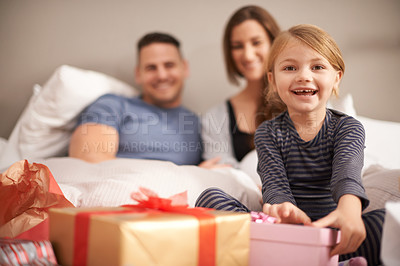 Buy stock photo Portrait, bedroom and girl with parents, gift or Christmas with celebration or bonding together. Face, family or kid with mother or father with festive season or present with happiness, home or smile