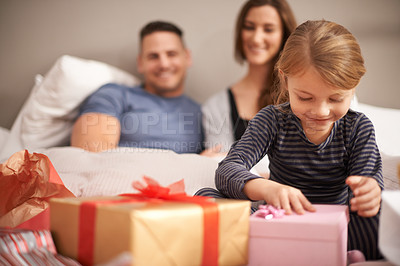 Buy stock photo Shot of a little girl receiving presents in bed from her parents