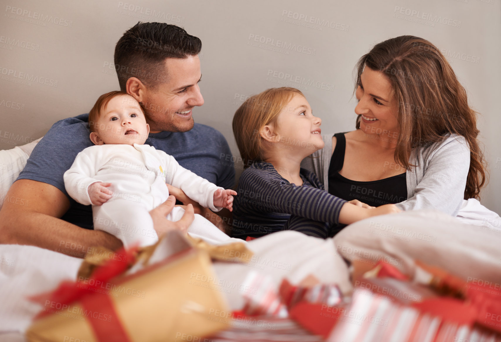 Buy stock photo Love, unboxing and happy family with gift in bed in celebration of birthday, event or mothers day at home together. Support, care and kids with parents in a bedroom with thank you, present or bonding