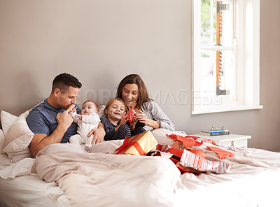 Buy stock photo Happy family, love and gift unboxing in a bed in celebration of birthday, event or mothers day at home together. Support, care and kids with parents in a bedroom with thank you, present or bonding
