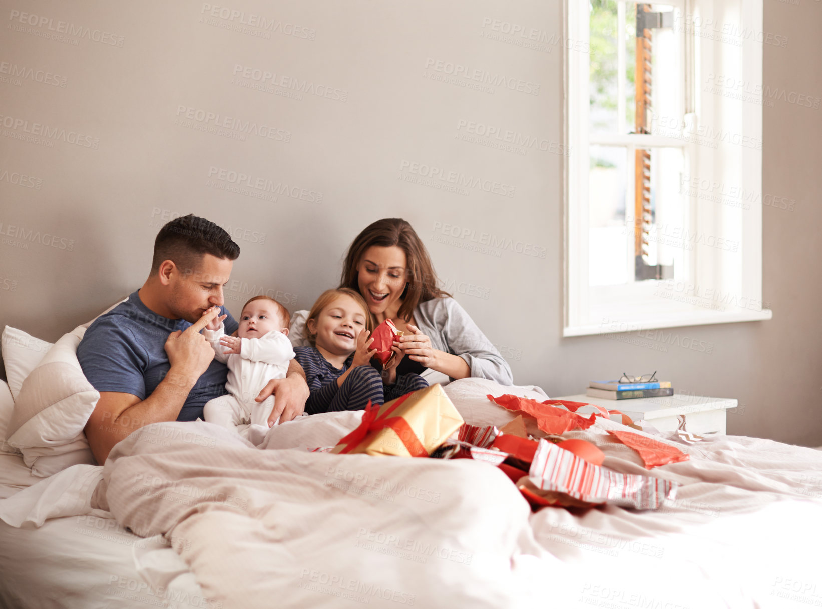 Buy stock photo Happy family, love and gift unboxing in a bed in celebration of birthday, event or mothers day at home together. Support, care and kids with parents in a bedroom with thank you, present or bonding