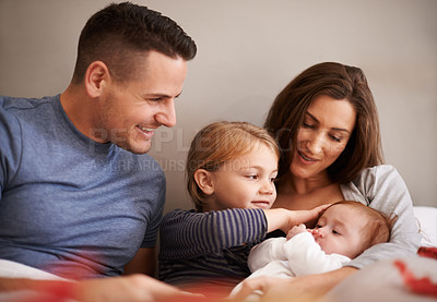 Buy stock photo Home, family and parents with baby, kids and bonding together with happiness and care in the morning. Bedroom, mother and father with children and holding infant with comfort, smile and weekend break
