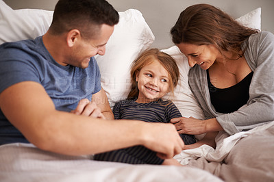 Buy stock photo Bedroom, morning and family with parents, girl and bonding together with fun and tickle with happiness. Home, mother and father with child and daughter with humor and relaxing with smile and cheerful