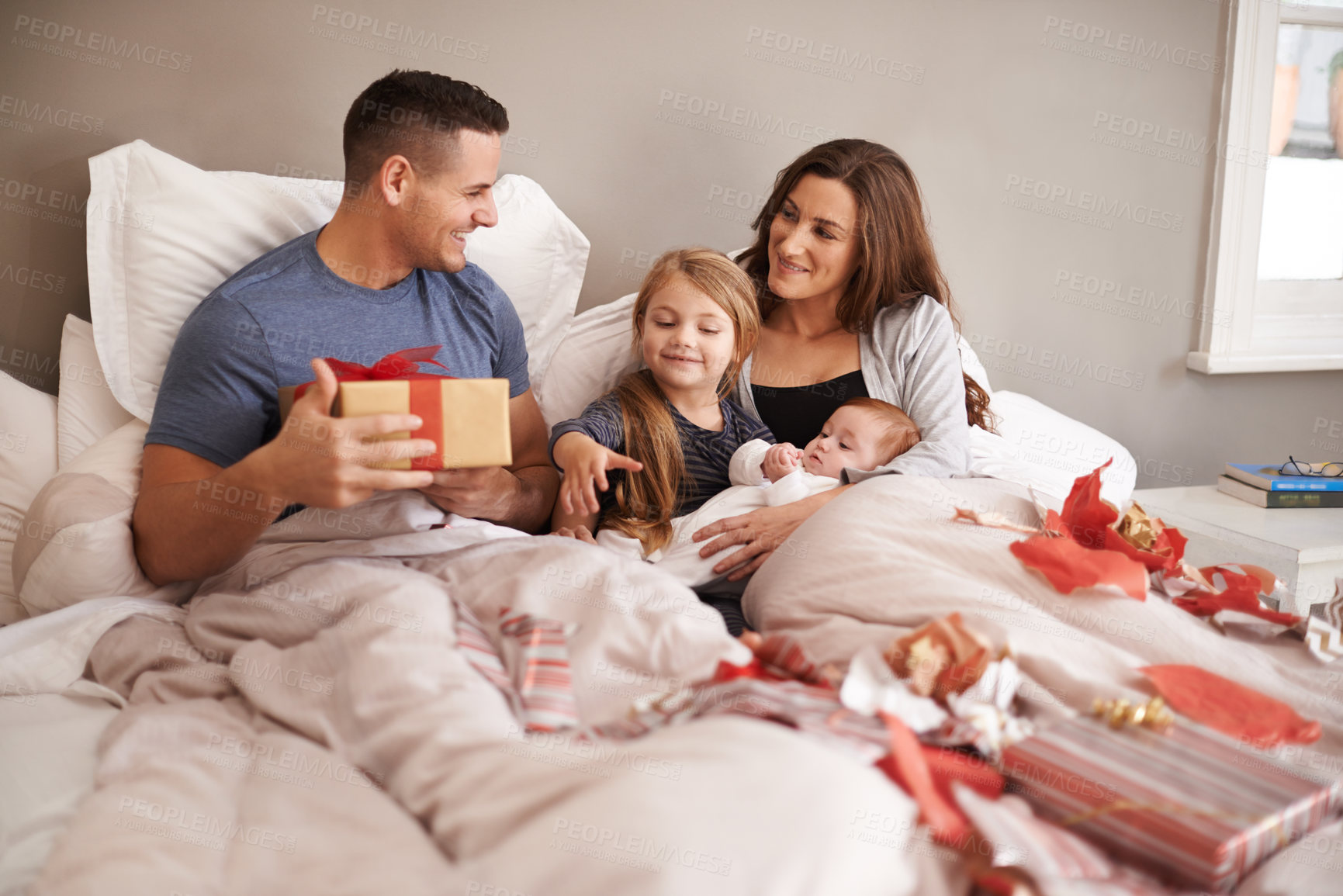 Buy stock photo Bedroom, gift or family with celebration, Christmas or bonding together with happiness, morning or festive season. Parents, mother or father with children, excited or kids with presents, home or Xmas