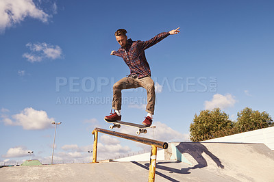Buy stock photo Shot of a skateboarder performing a trick on a rail