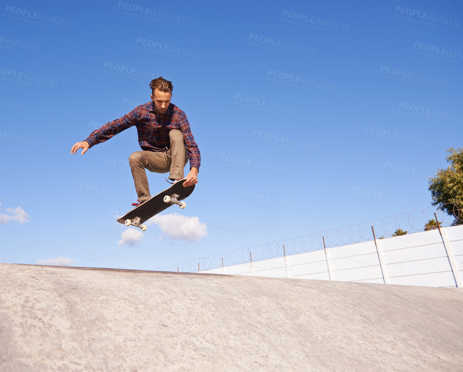 Buy stock photo A young man doing tricks on his skateboard at the skate park