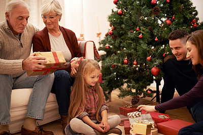 Buy stock photo Family, christmas tree and gifts with kids, parents and grandparents together with giving in living room. Home, happy and present with holiday and celebration at a party with love, care and bonding
