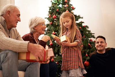 Buy stock photo Shot of a multi-generational family exchanging gifts at Christmas