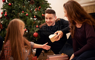Buy stock photo Family, present and christmas at home with love, giving and care together at holiday event. Happy, smile and tree with celebration, child and marriage in a house with young girl and festive gift