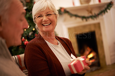 Buy stock photo Shot of a senior couple exchanging gifts at christmas