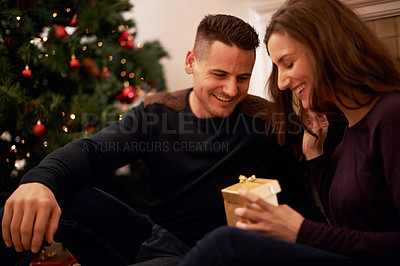Buy stock photo Couple, gift and Christmas in home with giving, love and support together with present. Celebration, holiday and tree with smile and happy with marriage in a house with romance and relationship