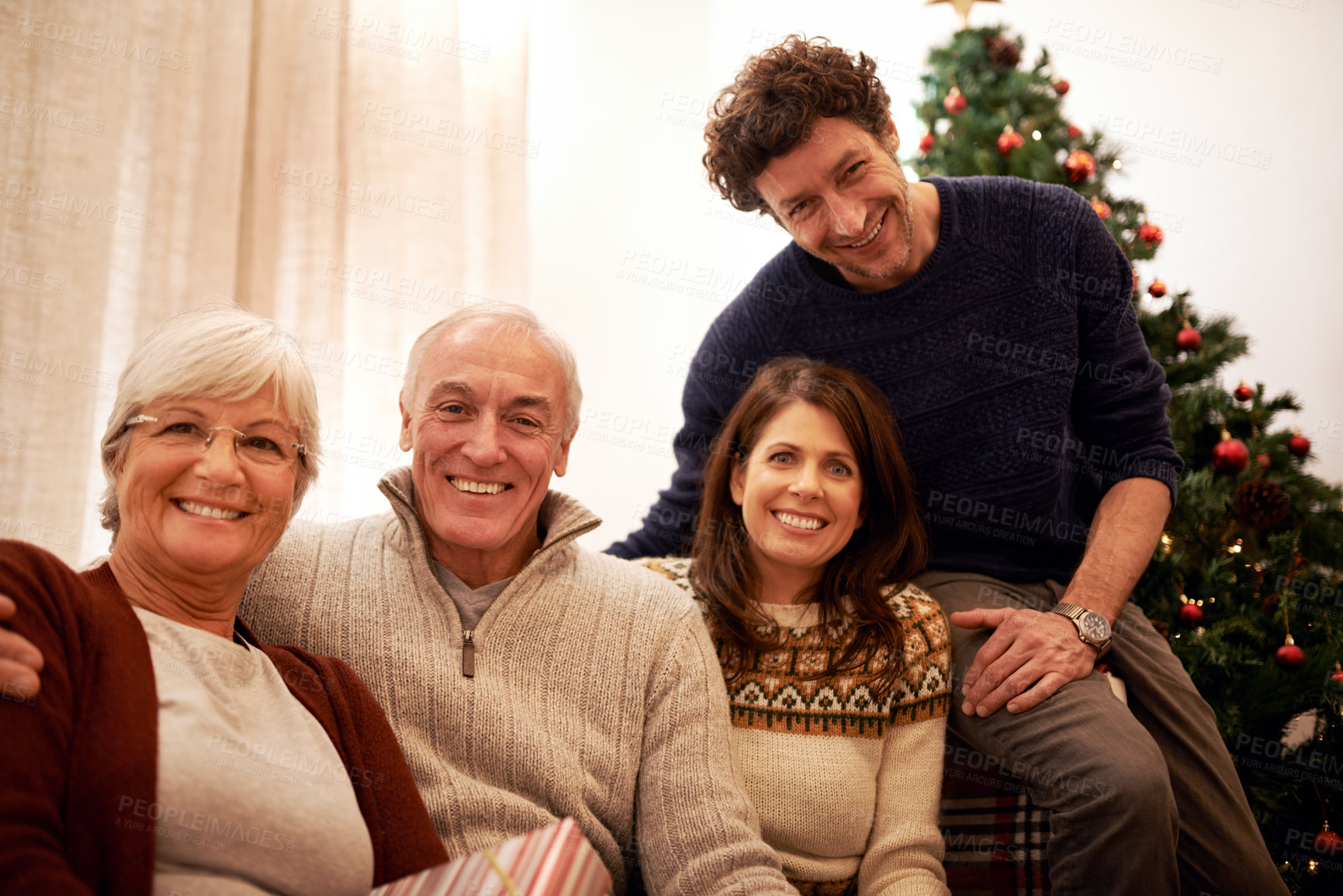 Buy stock photo Christmas, family and visit with a man, woman and senior parents together in the living room of a home. Portrait, happy and bonding with a mother, father and in laws celebrating the festive season