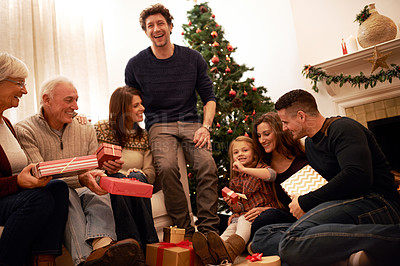 Buy stock photo Shot of a multi-generational family exchanging gifts at Christmas