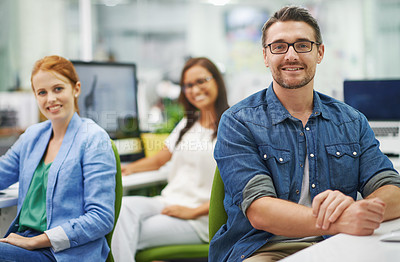 Buy stock photo Shot of three smiling colleagues working at the office