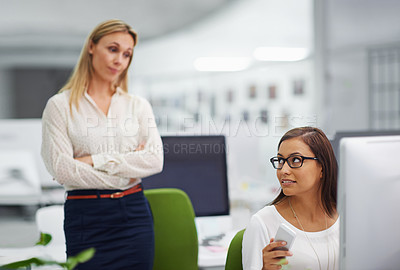 Buy stock photo Shot of an attractive female looking pensive being watched by her boss in an office setting