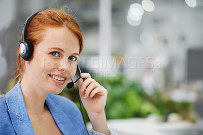 Buy stock photo Shot of an attractive red headed female wearing head sets in an office setting