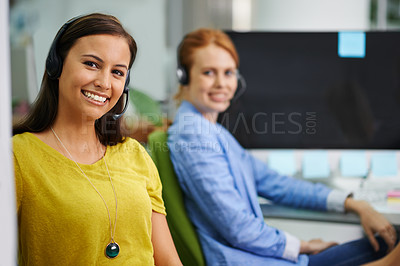 Buy stock photo Shot of two attractive female colleagues with headsets at the office