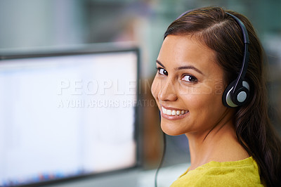 Buy stock photo Shot of an  attractive female with headsets on smiling while looking over her shoulder at work