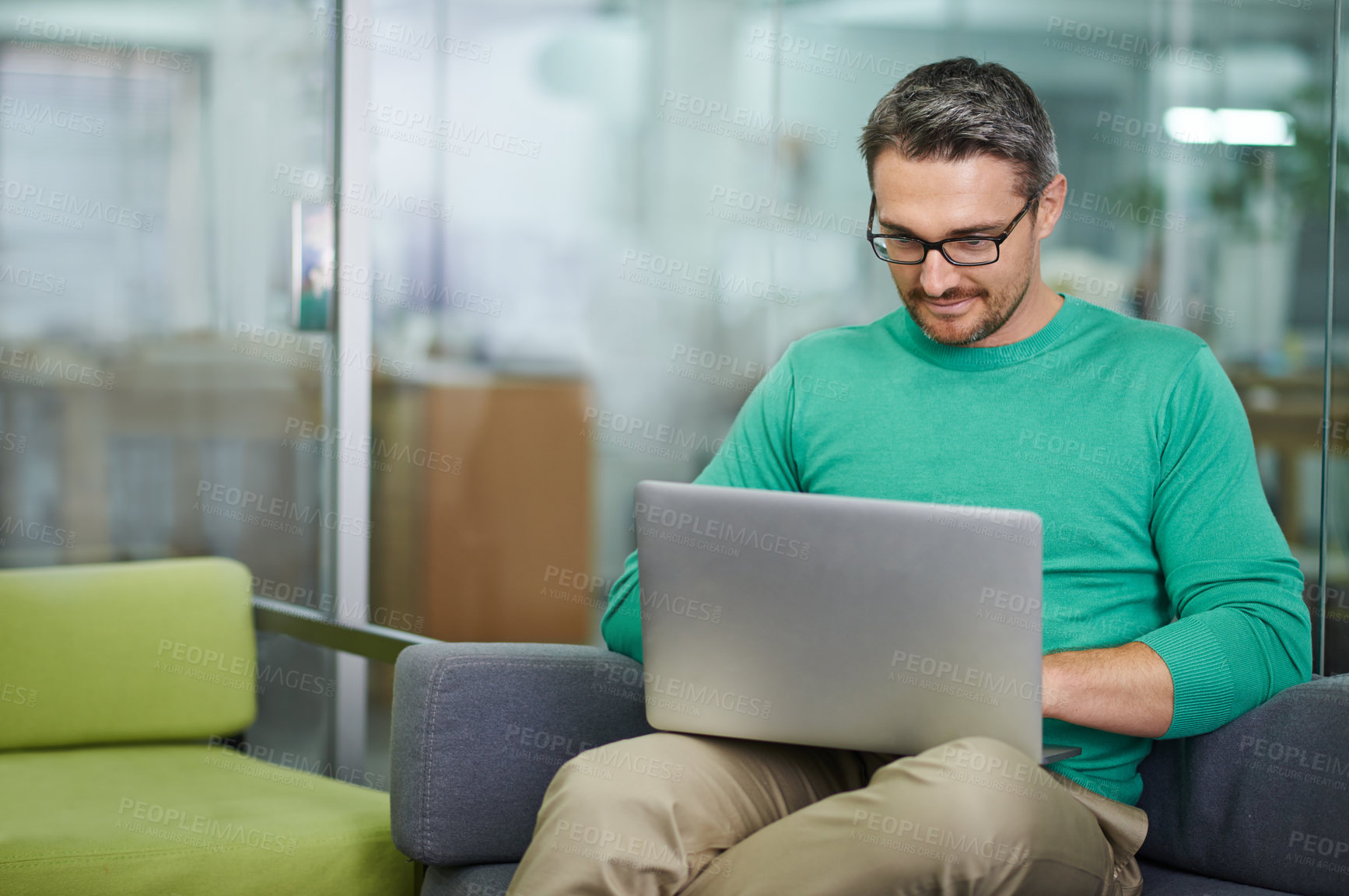 Buy stock photo Cropped shot of a handsome man working on his laptop