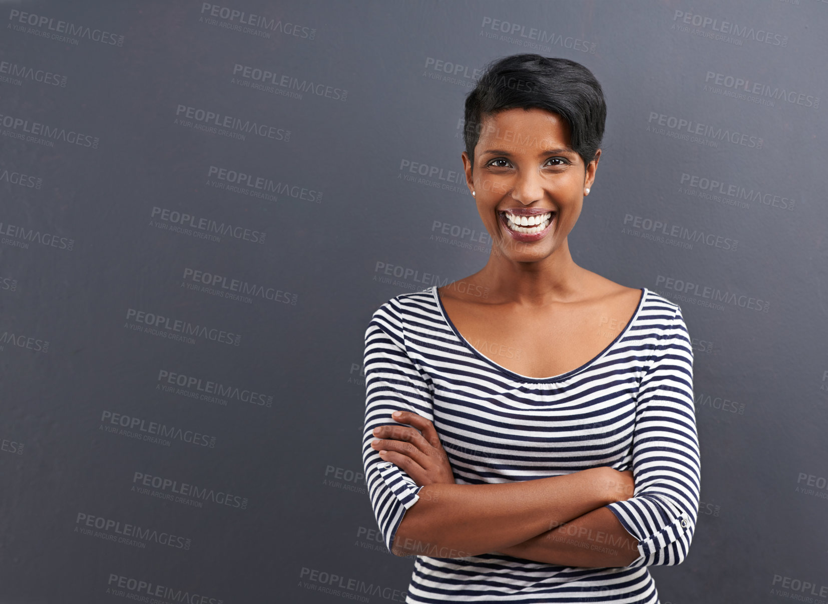 Buy stock photo Portrait of a happy young woman standing on a gray background