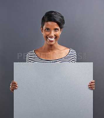 Buy stock photo Happy woman, portrait and presentation with billboard for advertising or marketing on a gray studio background. Young female person or Indian with smile, poster or notification sign on mockup space