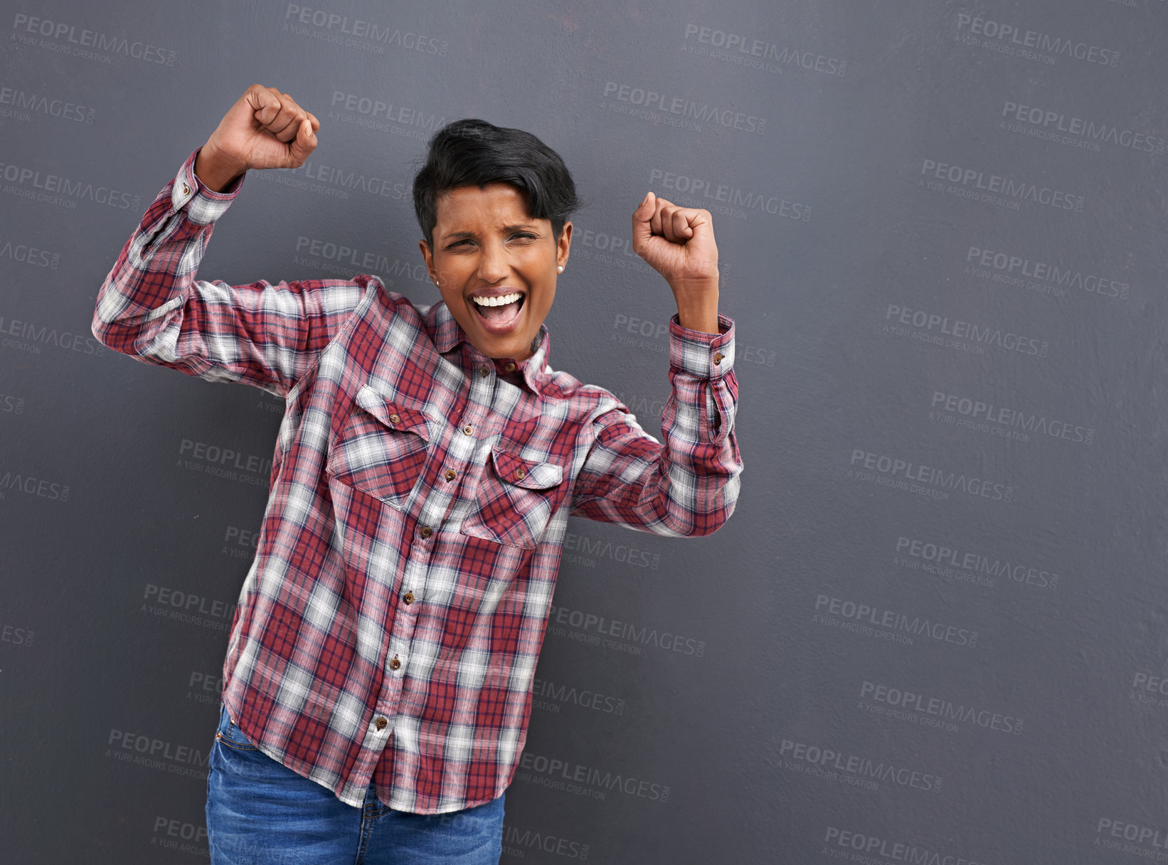 Buy stock photo Portrait of a happy young woman standing on a gray background