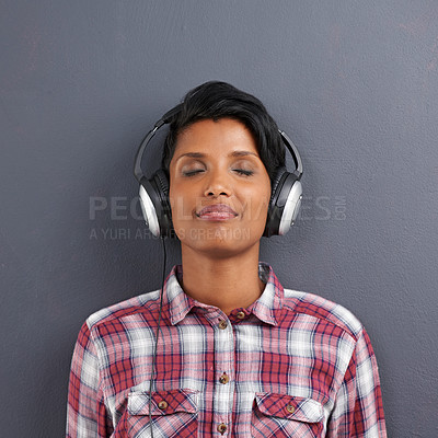 Buy stock photo Woman, relax and listening with headphones for music or podcast on a gray studio background. Calm, young female person or Indian with smile or enjoying audio sound track with headset on mockup space