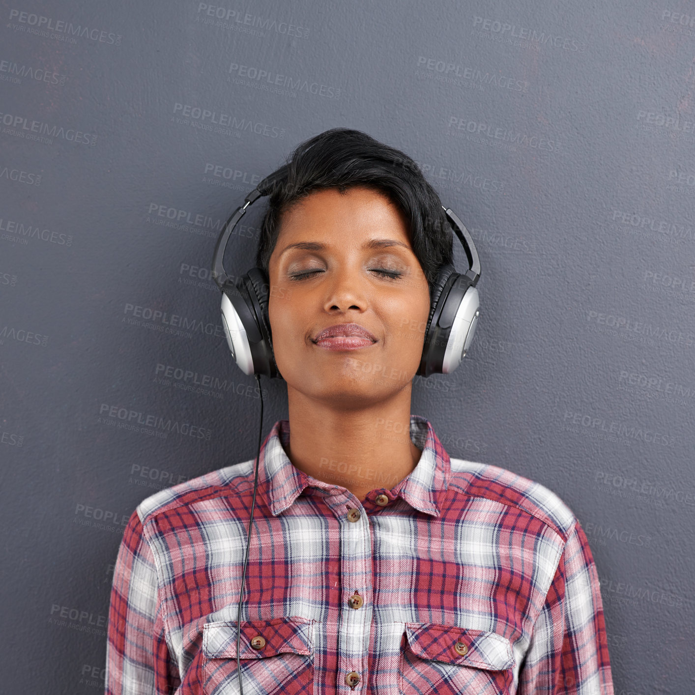 Buy stock photo Woman, relax and listening with headphones for music or podcast on a gray studio background. Calm, young female person or Indian with smile or enjoying audio sound track with headset on mockup space