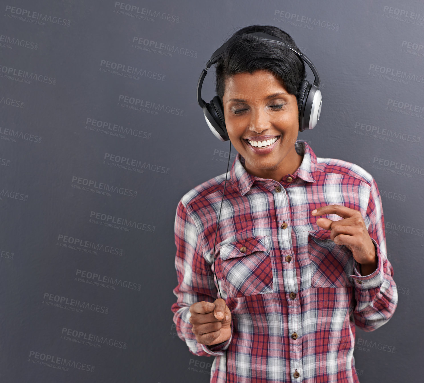 Buy stock photo Happy woman, dancing and listening with headphones for music or podcast on a gray studio background. Young female person or Indian with smile, enjoying audio sound track with headset on mockup space
