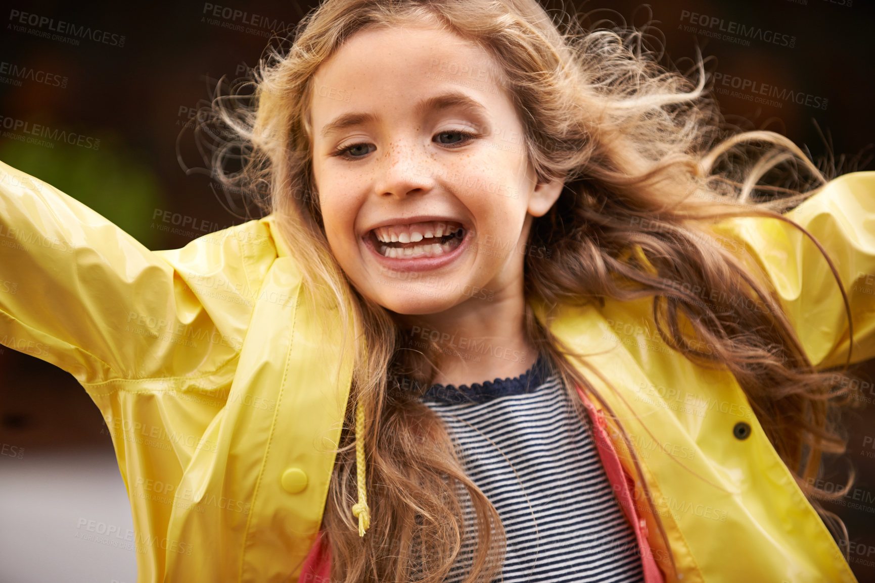 Buy stock photo Shot of a cute little girl wearing a raincoat playing outside