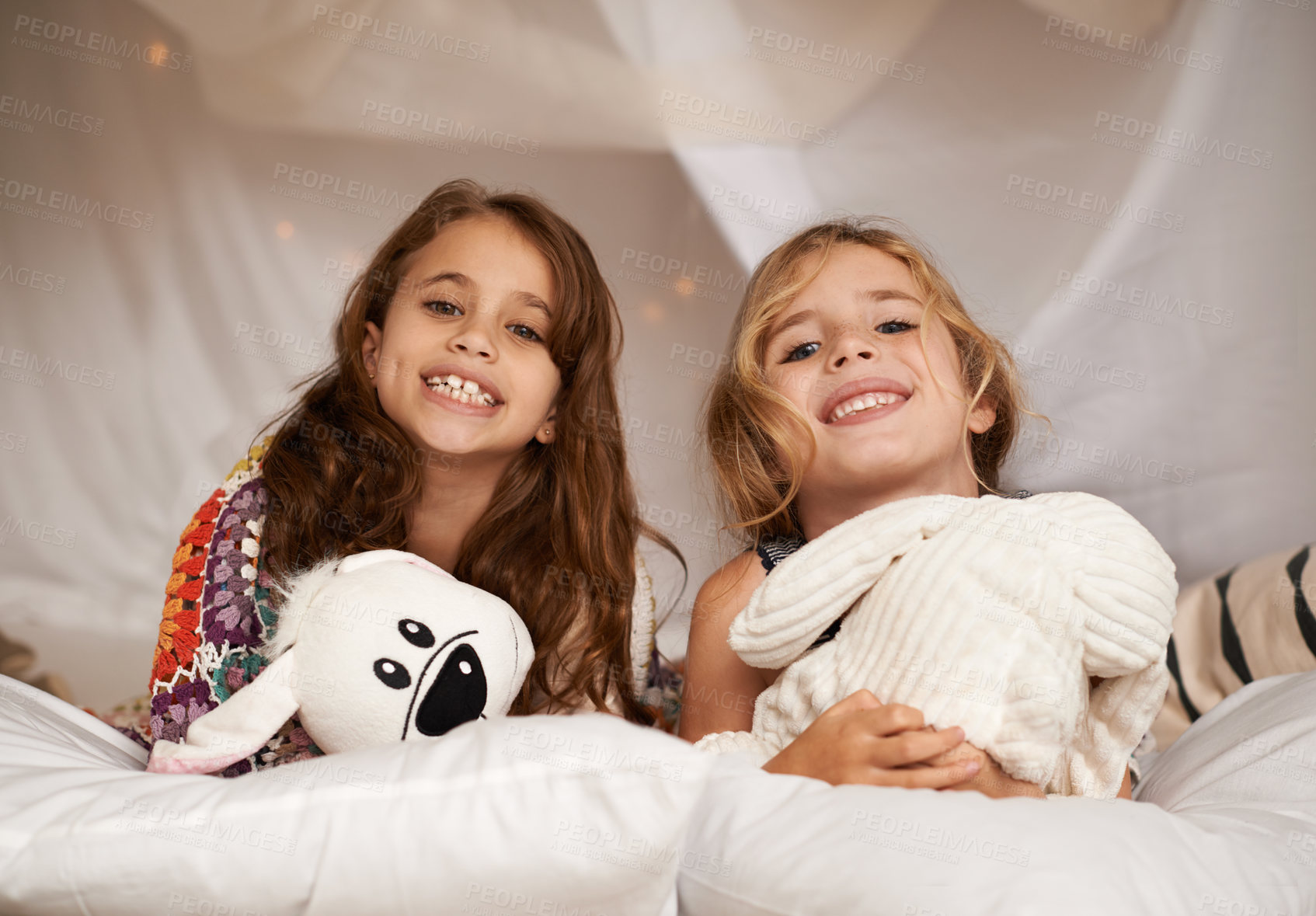 Buy stock photo Happy, sleepover and portrait of children in bedroom for playing, bonding and relax with toys in home. Night, friends and young girls on bed in tent or blanket fort for childhood, fun and happiness