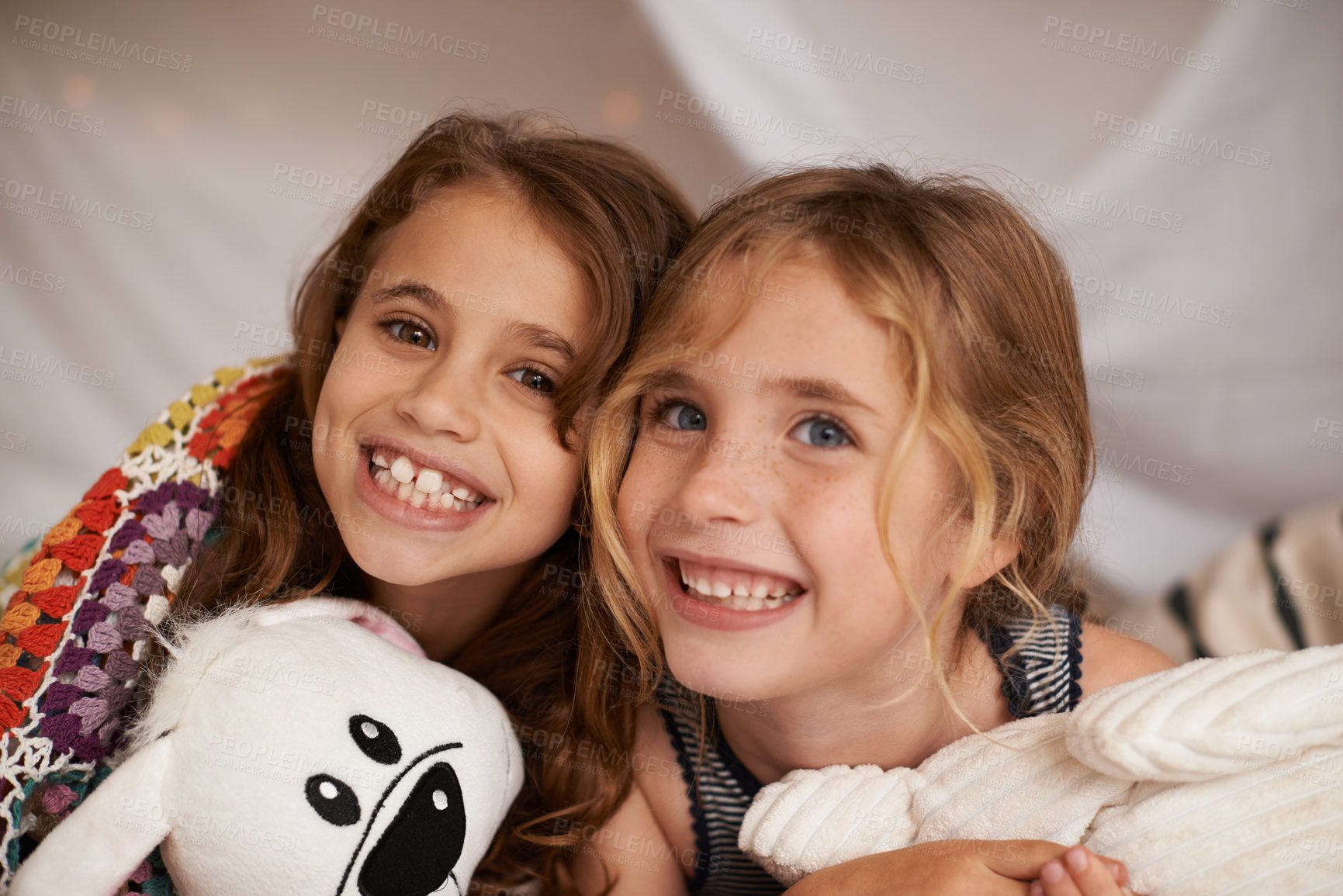 Buy stock photo Happy, toys and portrait of children in bedroom for playing, bonding and excited for sleepover in home. Night, friends and young girls on bed in tent or blanket fort for childhood, fun and happiness