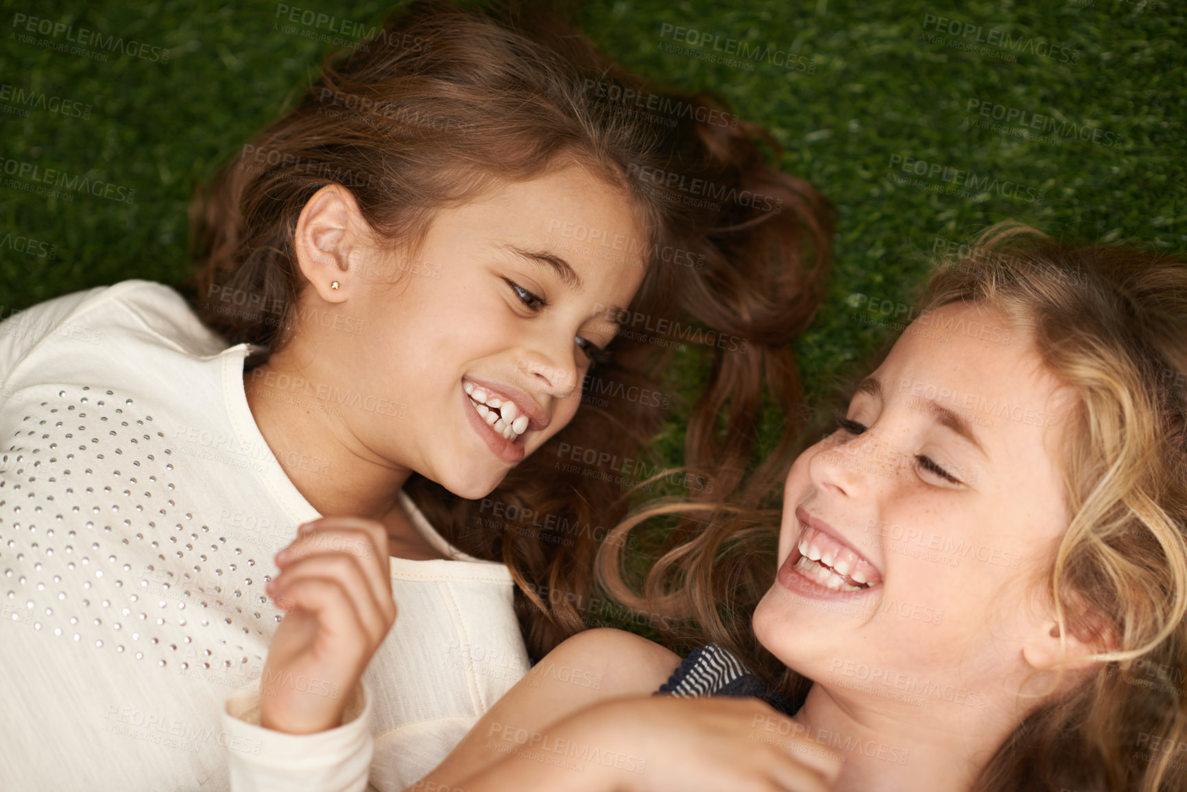 Buy stock photo Cropped shot of two little girls lying on their backs outside