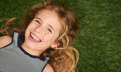 Buy stock photo Top view, child or girl in nature on floor, portrait and smile for joyful kid outdoors. Face, happy and summer season in garden or park for relax, grass and field for play and childhood development 