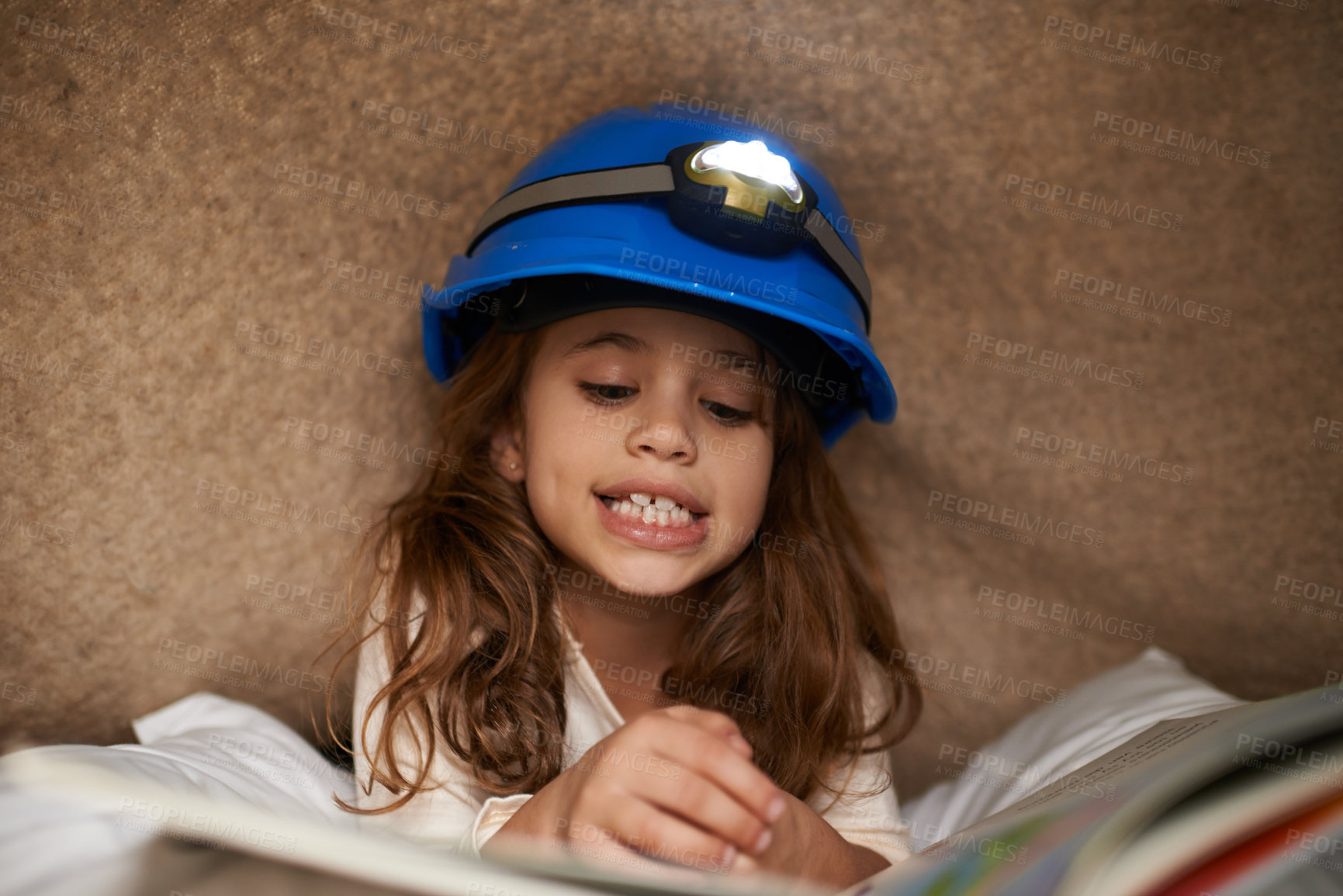 Buy stock photo Girl, child and book with headlamp for reading, above and learning with smile for education in family home. Kid, story and happy with light for info, language and literacy skills on floor in house