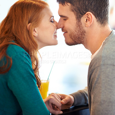 Buy stock photo Couple, date and kiss with love, coffee shop or restaurant with happiness together. Man, woman and romance for relationship, care and smile for flirting on break for relax or bonding in cafe